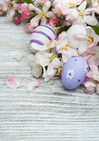 Easter eggs and spring apple blossom on a old wooden background