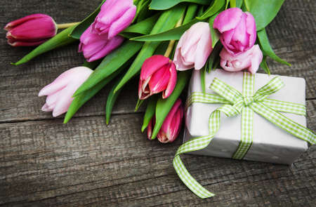 Spring tulips flowers and gift box on a old wooden backgroundの写真素材