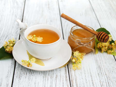 cup of herbal tea with linden flowers on a old wooden backgroundの写真素材