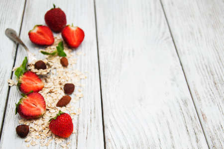 Muesli with strawberries on a old wooden tableの写真素材