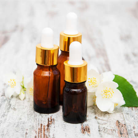 Massage oils and jasmine flowers on a wooden tableの写真素材