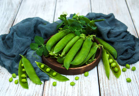 green peas  on rustic white wooden background