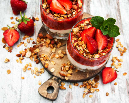 Yogurt and granola with strawberries for breakfastの写真素材