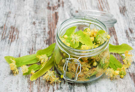 Jar with linden flowers on a old wooden tableの写真素材