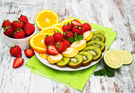 Plate with differents fruits on a wooden tableの写真素材