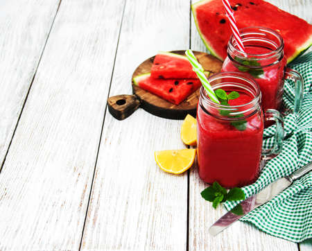 Jars with watermelon smoothie on a tableの写真素材