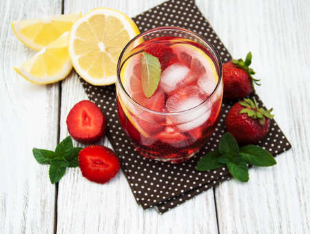 Lemonade with strawberries, lemon and mint on a old wooden tableの写真素材