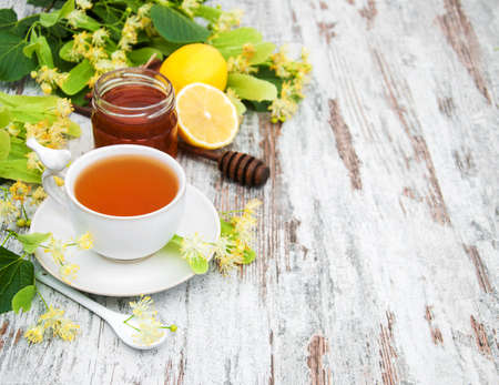 cup of herbal tea with linden flowers on a old wooden backgroundの写真素材