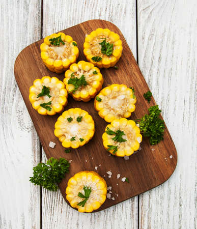 boiled corn on the cob with salt on a old wooden tableの写真素材