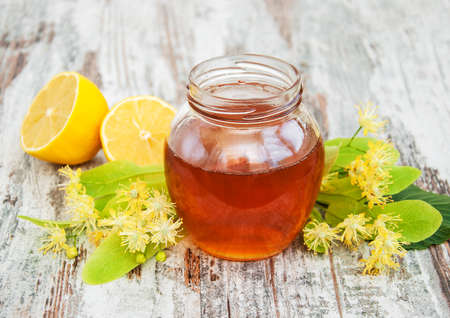 Honey  and linden flowers on a boardの写真素材