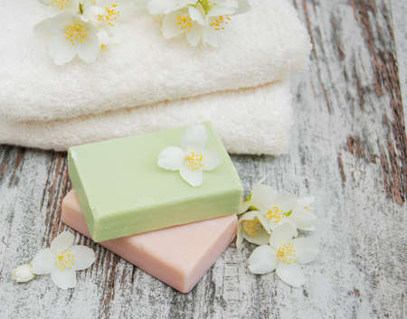 Handmade soap and jasmine flowers on a wooden tableの写真素材