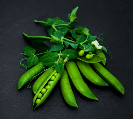 green peas  on a black stone boardの写真素材