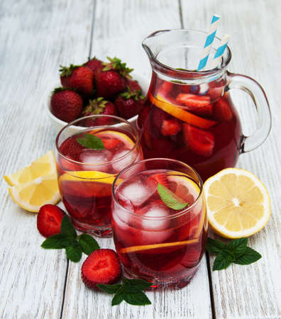 Lemonade with strawberries, lemon and mint on a old wooden tableの写真素材