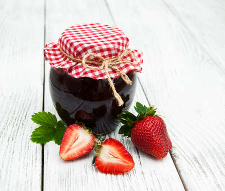 Strawberry jam and fresh strawberries on a wooden backgroundの写真素材