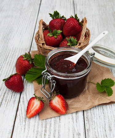 Strawberry jam and fresh strawberries on a wooden backgroundの写真素材