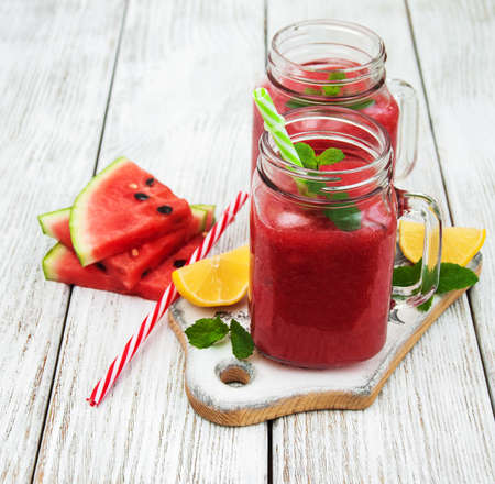 Jars with watermelon smoothie on a tableの写真素材