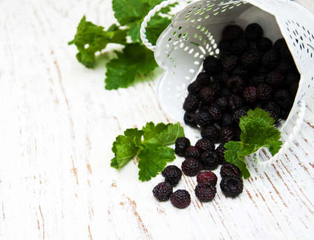 Fresh Blackberries with green leaves  on a wooden  backgroundの写真素材