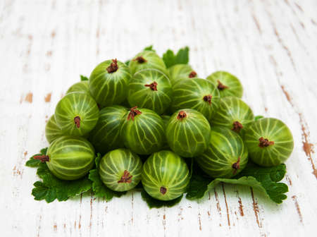 gooseberries with leaves on a old wooden backgroundの写真素材