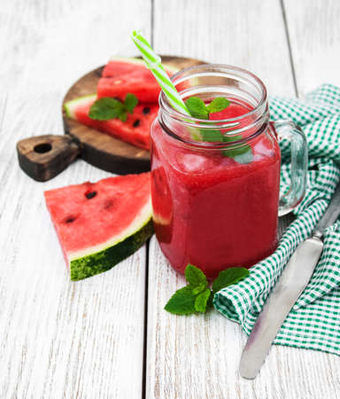 Jars with watermelon smoothie on a tableの写真素材