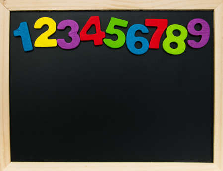 colorful wooden numbers on a blackboard backgroundの写真素材