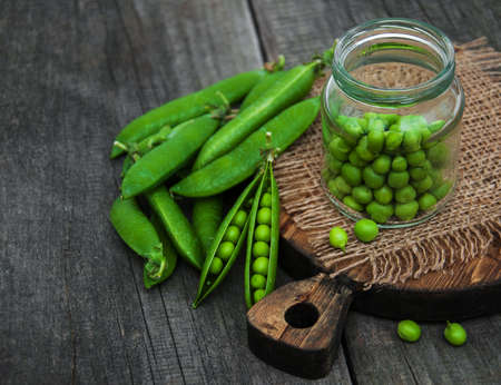 Jar with green peas on a wooden tableの写真素材