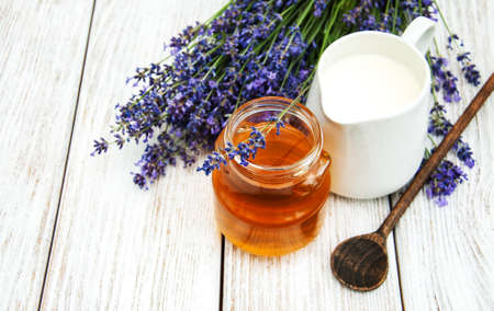 Honey and lavender  flowers on a wooden tableの写真素材