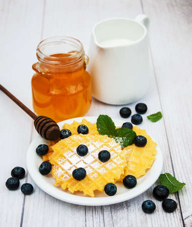 Waffles with blueberries on a old wooden tableの写真素材