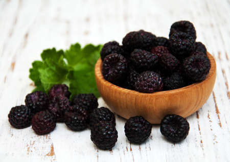 Bowl with Blackberries on a old wooden background