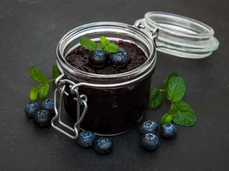 Jar with blueberry jam on a tableの写真素材
