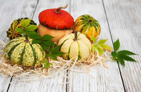 Pumpkins with autumn leaves on a old wooden table