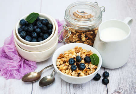 Bowl with granola and blueberries on a tableの写真素材