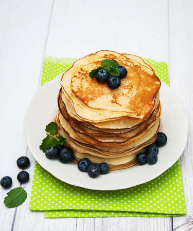 Plate with pancakes and blueberries on a tableの写真素材