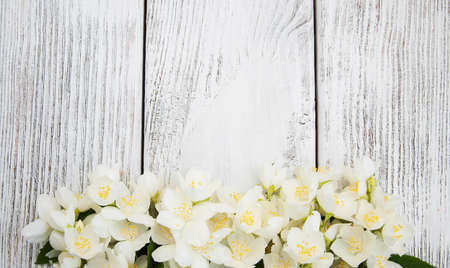 Border with jasmine flowers on a wooden backgroundの写真素材