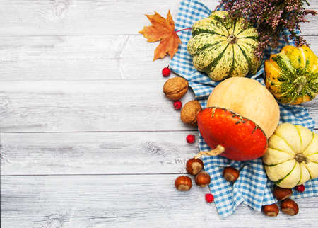 Pumpkins with autumn leaves on a old wooden tableの写真素材