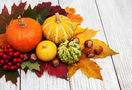Pumpkin and autumn  leaves on a old wooden tableの写真素材