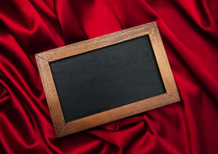 Empty blackboard on a red silk backgroundの写真素材