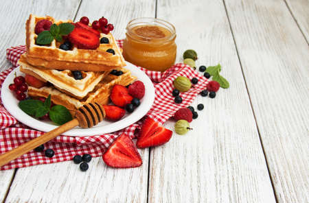 waffles with fresh berries on a old wooden table