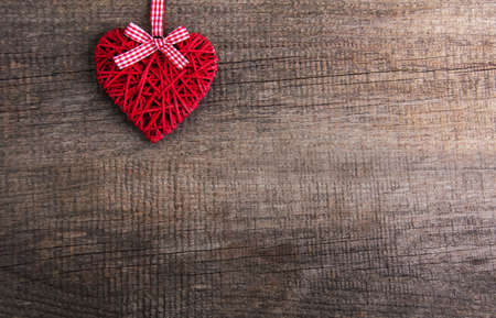 Christmas tree branches with heart decoration on a wooden backgroundの写真素材