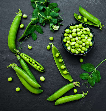 green peas  on a black stone boardの写真素材