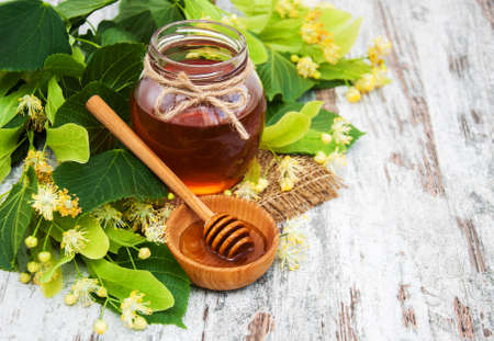 Honey  and linden flowers on a boardの写真素材