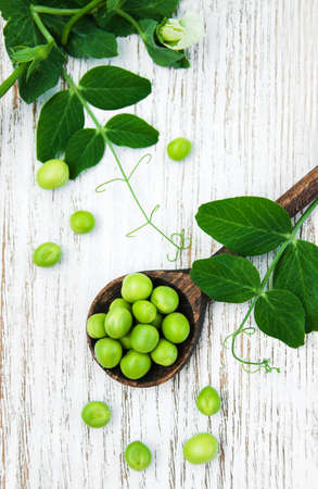 green peas  on rustic white wooden background