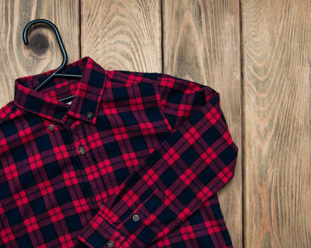 Checkered shirt  with hanger on a old wooden tableの写真素材