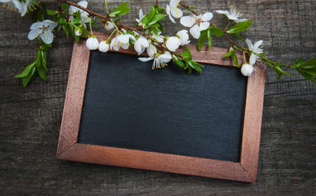 Spring cherries blossom and blackboard on a old wooden tableの写真素材