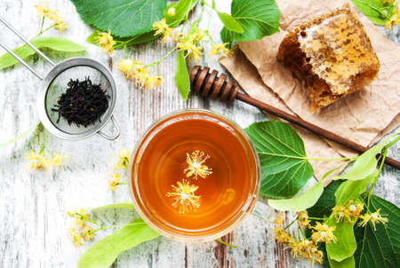 Honey comb, tea  and linden flowers on a boardの写真素材