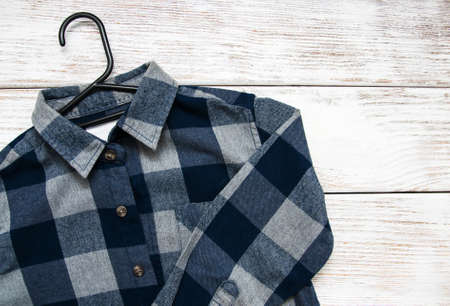 Checkered shirt  with hanger on a old wooden tableの写真素材