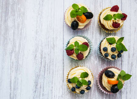 Cupcakes with fresh berries on a old wooden tableの写真素材