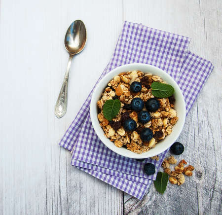 Bowl with granola and blueberries on a tableの写真素材