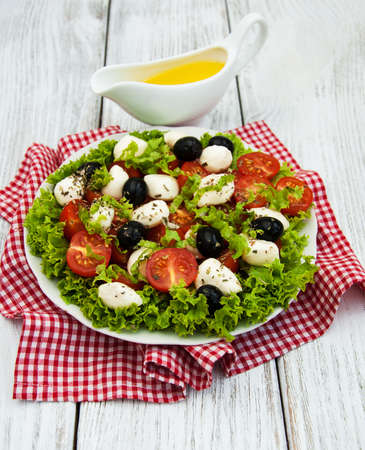 salad with mozarella cheese,  olives and tomatoの写真素材