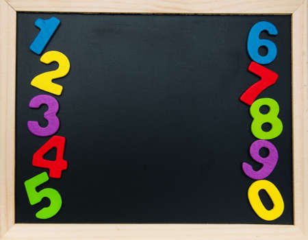 colorful wooden numbers on a blackboard backgroundの写真素材