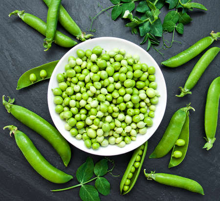 green peas  on a black stone boardの写真素材